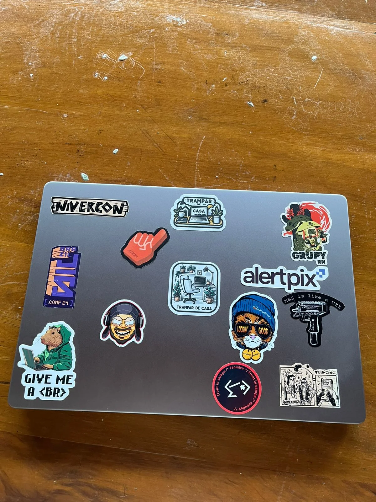 A MacBook M2 Pro 16GB Ram full of stickers on a wood table